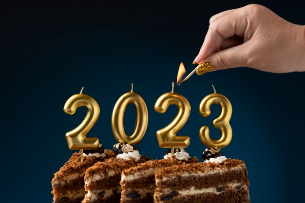side view hand lighting candles on cake