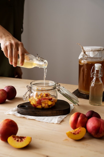 side view hand pouring kombucha in jar
