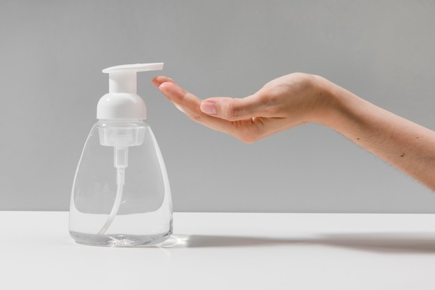 Side view of hand using hand sanitizer