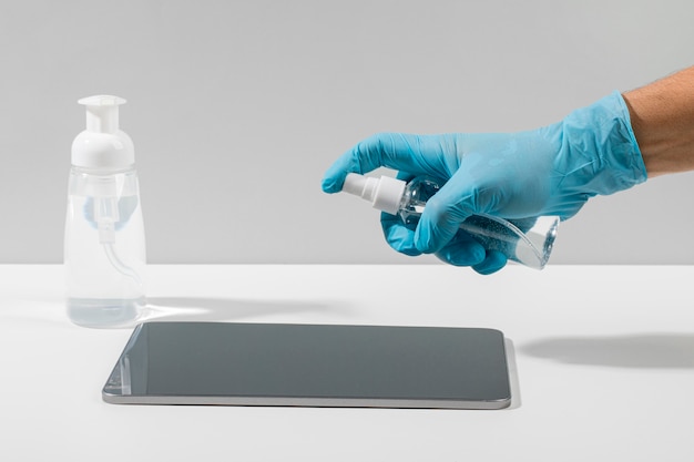 Side view of hand with surgical glove disinfecting tablet