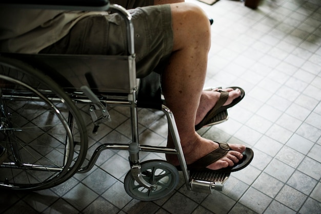 Foto vista laterale di handicap uomo anziano sulla sedia a rotelle