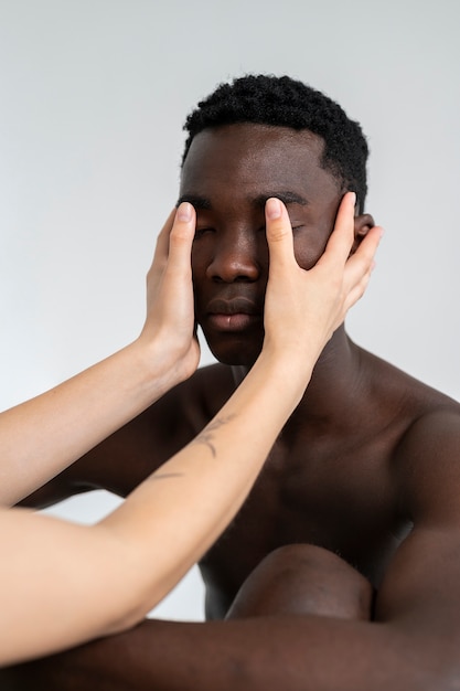 Side view hands holding man's face