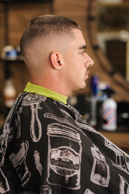 Side view of handsome man in barbershop man in glasses with finish hairstyle