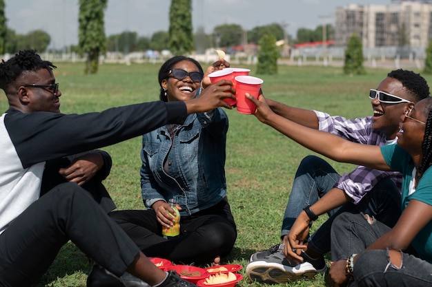 Photo side view happy friends with plastic cups