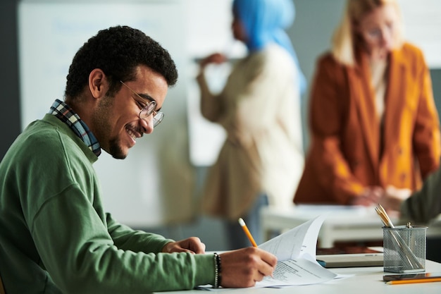 Side view of happy middle eastern student carrying out grammar test