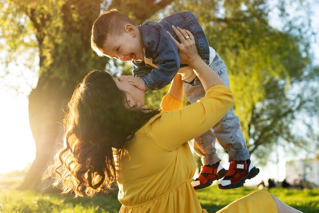 Side view happy mother holding boy up