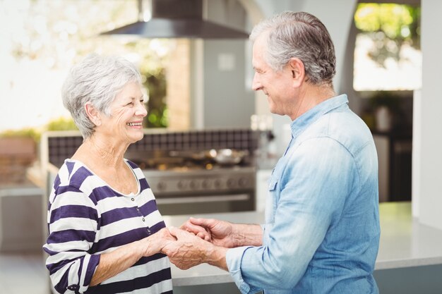 Side view of happy senior couple holding hands