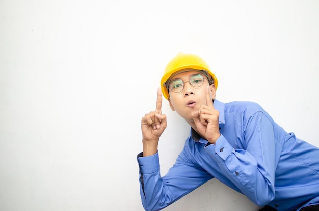 Side view of a happy shocked asian consrtuction worker pointing finger and presenting something ads