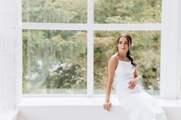 Side view happy woman dreaming while looking at window indoor. She having rest during labor