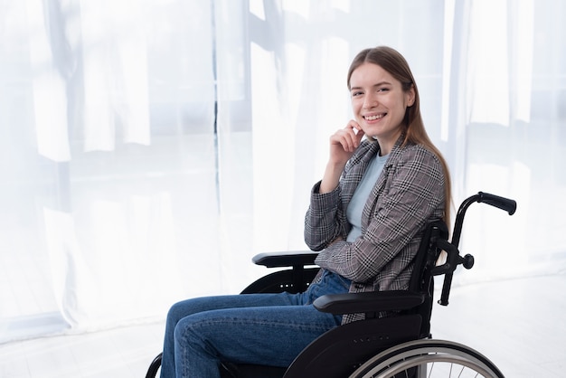 Photo side view happy woman in wheelchair