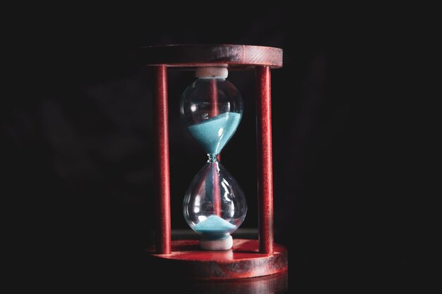 A side view of an hourglass with falling sand