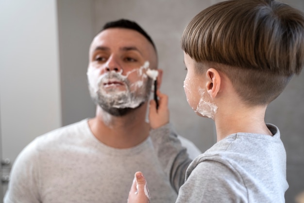 写真 父が剃るのを手伝う側面図の子供