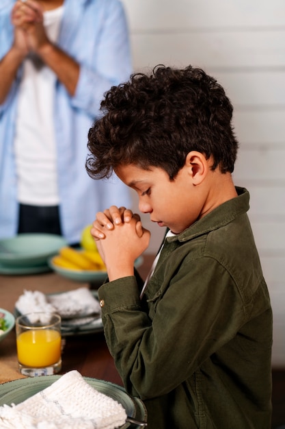 Side view kid praying at home