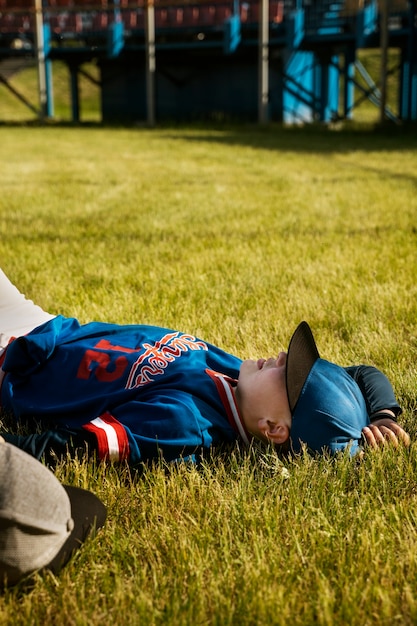 写真 草の上に横たわっている側面図の子供たち