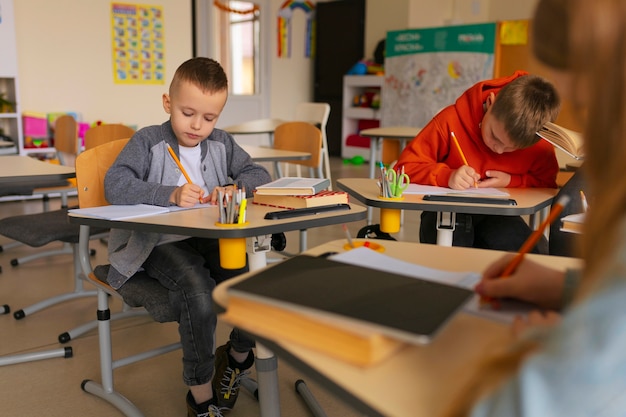 Foto vista laterale bambini che imparano a scuola