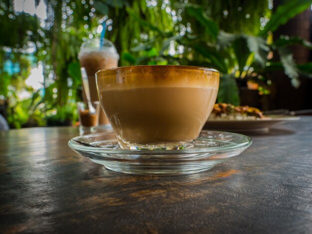 Side view latte art coffee on wood table, low key