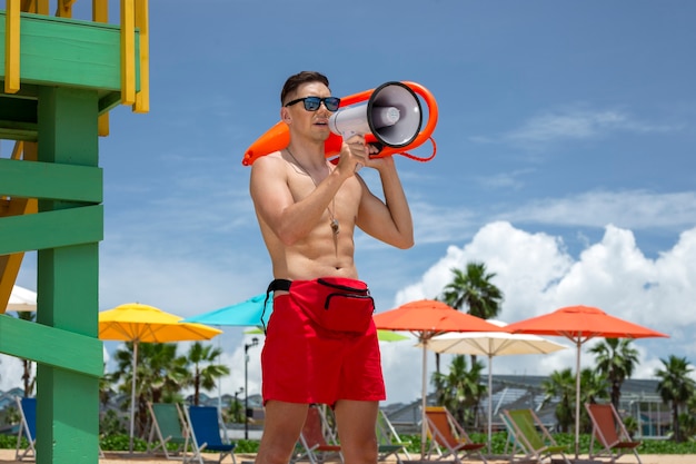 Photo side view lifeguard holding megaphone