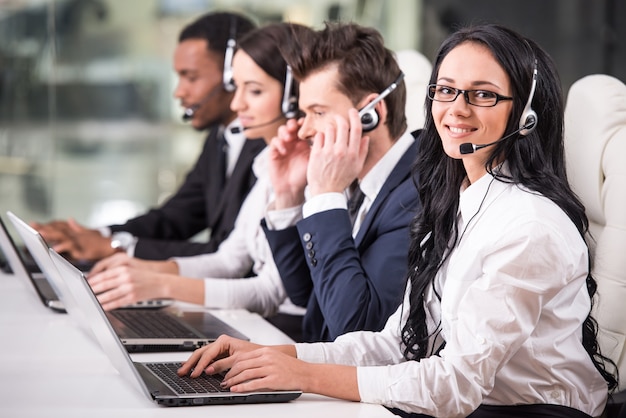 Side view of line of call centre employees are working.