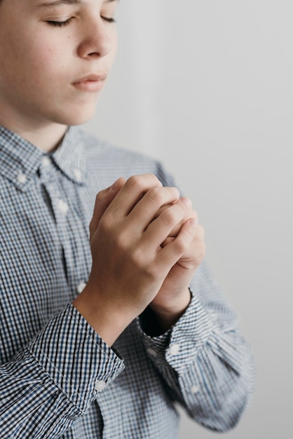 Side view little boy praying close-up