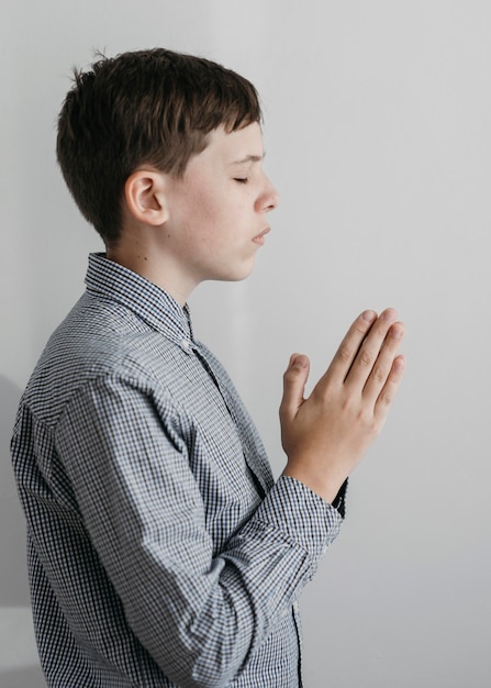 祈っている小さな男の子の側面図