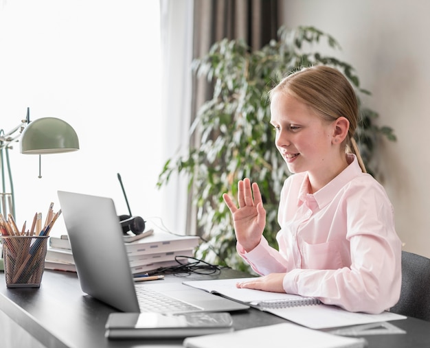 Vista laterale bambina che partecipa alla lezione online