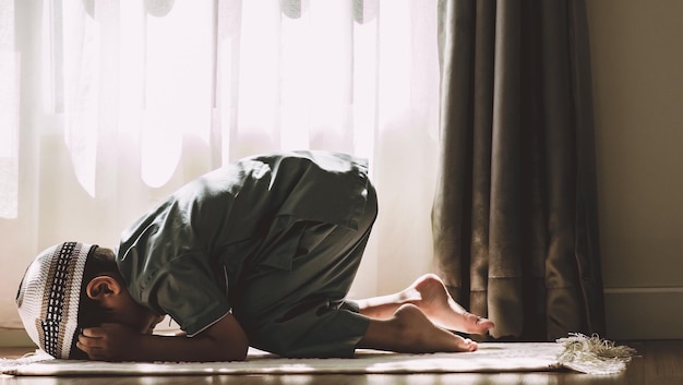 Photo side view of little muslim boy praying to god