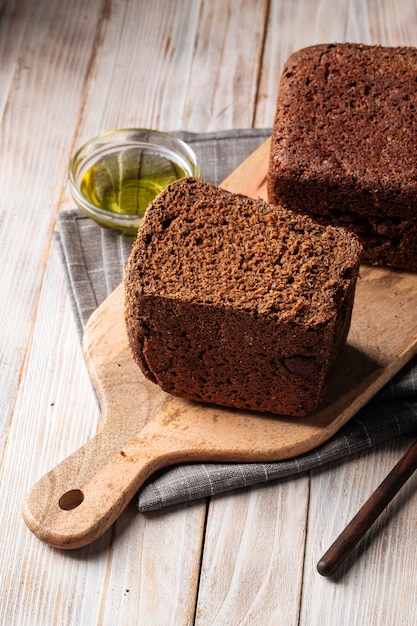 Side view on loaf of rye bread on the wooden cutting board