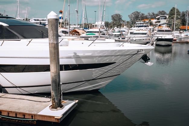 Side view of a luxury white yacht standing on the parking lot near another yachts