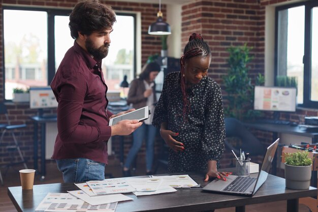 Photo side view of male friends working in office