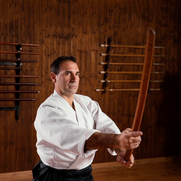 Photo side view of male martial arts instructor in the practice hall