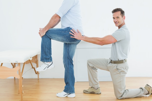 Side view of a male physiotherapist examining mans back