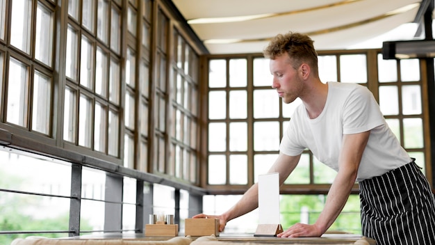 Photo side view of male waiter preparing tables