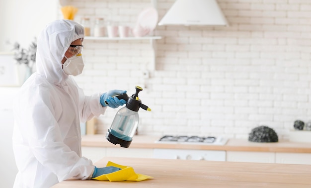 Photo side view man disinfecting table