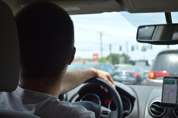 Side view of man driving car