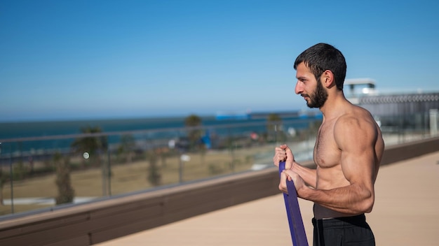 Photo side view of man exercising at beach against sky