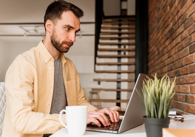 Side view man having video call on laptop