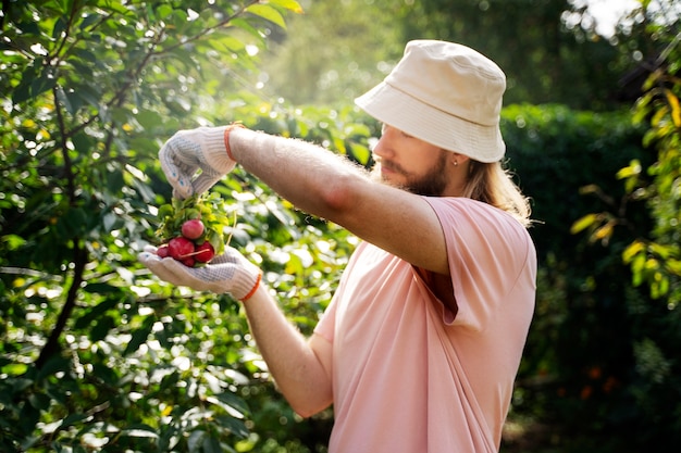 Photo side view man holding radishes