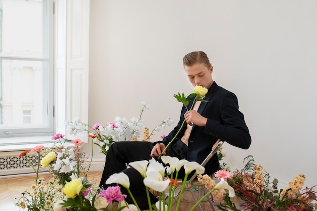 Photo side view man holding yellow flower