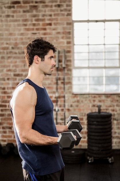 Side view of man lifting dumbbells