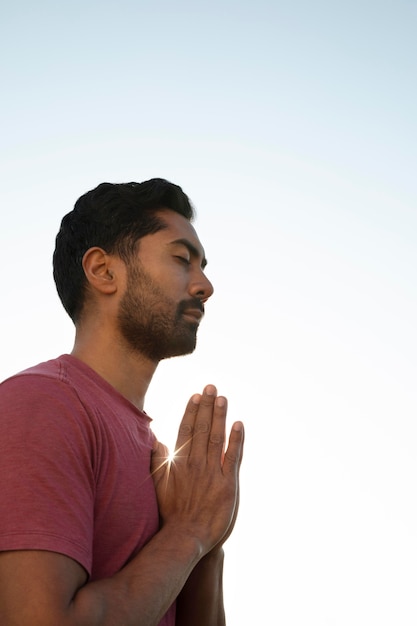 Side view of man meditating outdoors