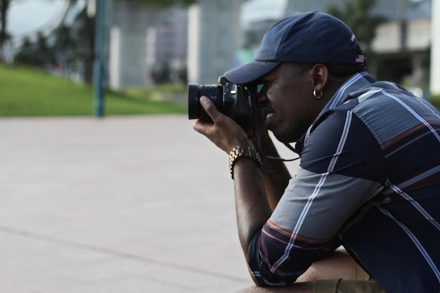 side view of man photographing on street using camera