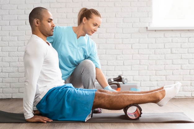 Side view of man and physiotherapist doing exercises