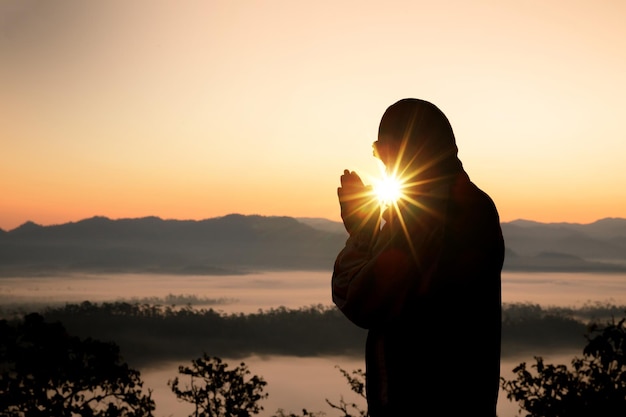 夕暮れの時に空に向かって祈っている男の横の景色