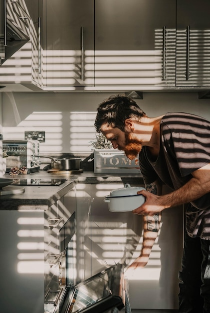 Photo side view of man preparing food at home