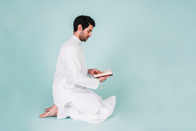 Side view of man reading in quran