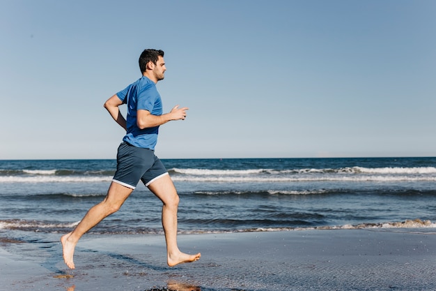 Side view of man running at the beach