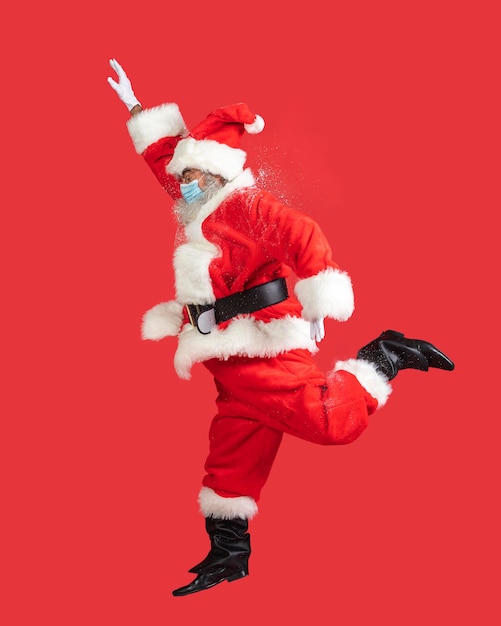 Photo side view of man in santa costume with medical mask