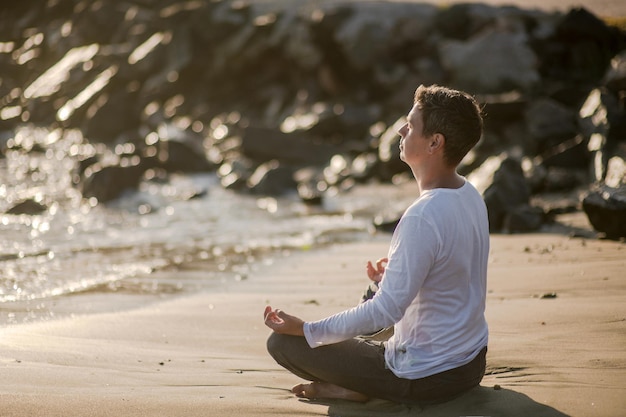 Side view of man sitting at beach