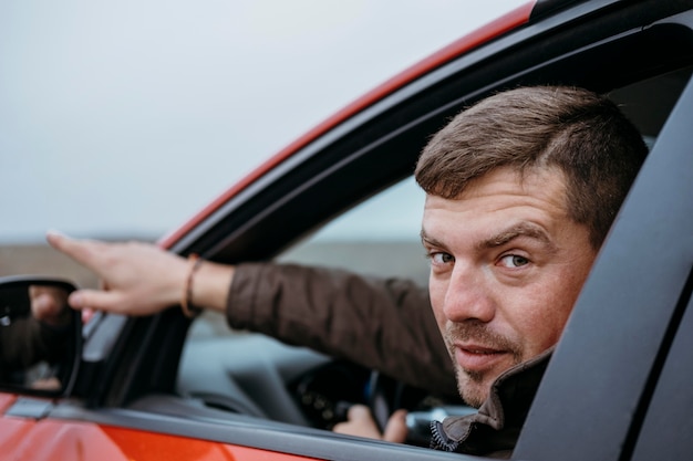 Photo side view of man sitting in the car