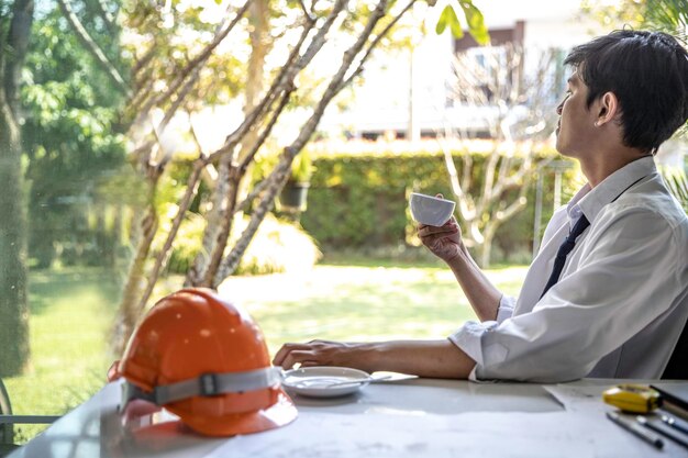 Photo side view of a man sitting on table